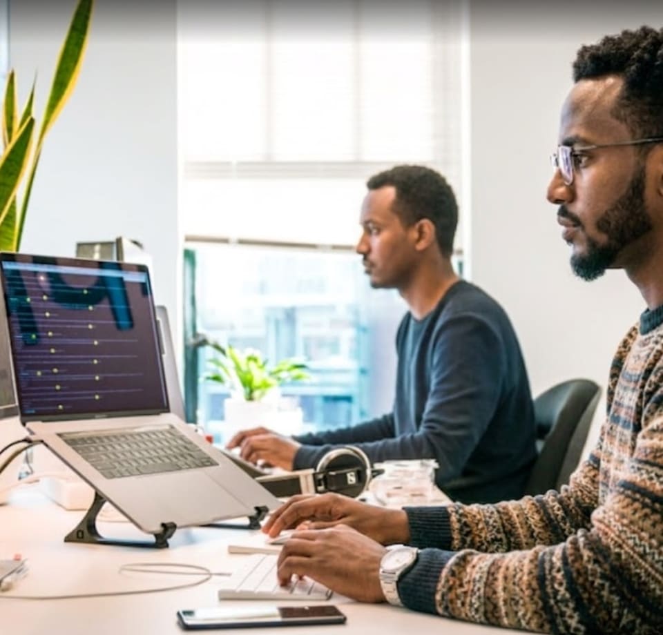Two REMENAR designers working at their desks in the Dubai studio.